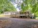 The exterior of a home features a wooden ramp leading to a front porch, surrounded by a gravel yard at 84 Sumner Nw Ave, Concord, NC 28027