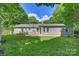 The back exterior of the home overlooks a spacious backyard and features neutral siding and ample windows at 901 Scaleybark Rd, Charlotte, NC 28209
