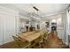 Open dining room with hardwood floors features a modern light fixture and flows into the updated kitchen at 901 Scaleybark Rd, Charlotte, NC 28209