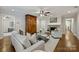 Comfortable living room featuring hardwood floors, neutral furniture, and a stone fireplace at 901 Scaleybark Rd, Charlotte, NC 28209