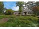 A view of the backyard with mature trees, grass, and landscaping at 9625-A Surface Hill Rd, Mint Hill, NC 28227