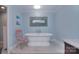Serene bathroom featuring a standalone tub, decorative mirror, and a pastel color scheme at 9625 Surface Hill Rd, Mint Hill, NC 28227