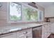 Bright kitchen with white cabinets, granite countertops, and a view of the wooded outdoors at 9625-A Surface Hill Rd, Mint Hill, NC 28227