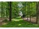 Lush backyard offering privacy and a glimpse of the beautiful home through the trees at 9831 Sedgefield Dr, Waxhaw, NC 28173