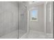 Bathroom featuring white tiling, a shower with a glass enclosure, and natural light at 9831 Sedgefield Dr, Waxhaw, NC 28173