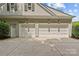 Spacious three-car garage with carriage-style doors and exterior lighting fixtures at 9831 Sedgefield Dr, Waxhaw, NC 28173