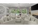 Bright living room with white furniture, fireplace, and view of the pool through large windows at 9831 Sedgefield Dr, Waxhaw, NC 28173