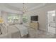 Bright main bedroom with large windows, chandelier, sitting area, and ensuite bathroom access at 9831 Sedgefield Dr, Waxhaw, NC 28173