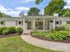 Charming brick home featuring a covered porch with rocking chairs and landscaped front yard at 1031 Eldorado Ave, Charlotte, NC 28262