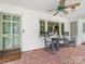 Charming front porch featuring a brick floor, comfortable rocking chairs, and a ceiling fan at 1031 Eldorado Ave, Charlotte, NC 28262