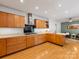 Open kitchen with a gas range, tile backsplash, and wood cabinets overlooking the living area at 1031 Eldorado Ave, Charlotte, NC 28262