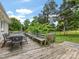 Spacious wooden deck with an outdoor dining set, bench, and a view of the expansive backyard at 1031 Eldorado Ave, Charlotte, NC 28262