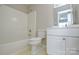 Bathroom with white fixtures, including toilet, vanity, and bathtub with shower at 105 Woodsong Ln, Mooresville, NC 28117