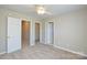 Neutral carpeted bedroom with two doorways and view into closet, offering flexibility and storage at 105 Woodsong Ln, Mooresville, NC 28117