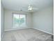 Bright bedroom with carpet, ceiling fan, and large window bringing in natural light at 105 Woodsong Ln, Mooresville, NC 28117