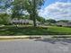 Community view featuring grassy common area with mature trees and picnic benches for residents' enjoyment at 105 Woodsong Ln, Mooresville, NC 28117