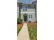 Exterior of a townhome featuring manicured lawn and walkway to the front door at 105 Woodsong Ln, Mooresville, NC 28117