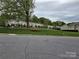 A row of townhomes set on a grassy hillside, complemented by mature trees and picnic areas at 105 Woodsong Ln, Mooresville, NC 28117