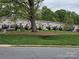 A neighborhood with townhomes nestled on a grassy hillside, featuring mature trees and community picnic areas at 105 Woodsong Ln, Mooresville, NC 28117