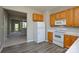 Cozy kitchen with white appliances, wooden cabinets, and seamless flow to the carpeted living area at 105 Woodsong Ln, Mooresville, NC 28117