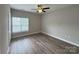 Bedroom featuring wood floors, a ceiling fan, and a bright window at 10673 Hill Point Ct, Charlotte, NC 28262