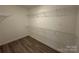 Walk-in closet with built-in shelving and wood-look flooring at 10673 Hill Point Ct, Charlotte, NC 28262