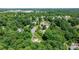 Bird's eye view of property in a neighborhood with mature trees and a small overgrown pool in the distance at 109 Gatwick Ct, Statesville, NC 28677