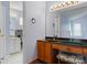 Bathroom featuring a vanity with dark countertop, wood cabinets, decorative stool, and well-lit mirror at 109 Gatwick Ct, Statesville, NC 28677