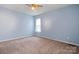 Bedroom with light blue walls and carpeted floors, featuring a window with sheer curtains at 109 Gatwick Ct, Statesville, NC 28677
