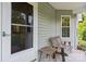 Close-up of a cozy front porch featuring rustic wooden furniture and a welcoming atmosphere at 109 Gatwick Ct, Statesville, NC 28677