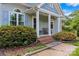 Inviting front porch with a seating area, brick accents, and beautifully landscaped surroundings at 109 Gatwick Ct, Statesville, NC 28677