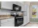Modern kitchen with stainless steel range and microwave, plus white subway tile backsplash at 109 Gatwick Ct, Statesville, NC 28677