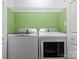 Laundry room featuring a washer and dryer with overhead shelving, providing ample space at 109 Gatwick Ct, Statesville, NC 28677