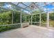 Bright sunroom featuring tile flooring, glass ceiling, and views of lush greenery at 109 Gatwick Ct, Statesville, NC 28677
