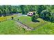 Stunning aerial view of a charming home with a pond, surrounded by lush greenery and a fenced yard at 11227 Cool Springs Rd, Cleveland, NC 27013