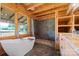 Bright bathroom features a modern tub and shower, sleek tile, and wood-framed windows at 11227 Cool Springs Rd, Cleveland, NC 27013