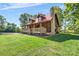 Side view featuring a stone chimney and a long, covered porch at 11227 Cool Springs Rd, Cleveland, NC 27013