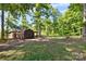 Backyard shed surrounded by green grass and trees offers extra storage and functionality to the property at 11227 Cool Springs Rd, Cleveland, NC 27013