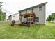 Backyard deck featuring a covered seating area, grill, and a lush green lawn at 120 Tranquil Ct, Locust, NC 28097