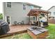 Backyard deck with a covered seating area, grill, and a modern fire pit, great for entertaining at 120 Tranquil Ct, Locust, NC 28097
