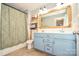 Charming bathroom featuring double sinks, blue cabinets, and a framed mirror at 120 Tranquil Ct, Locust, NC 28097