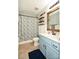 A pleasant bathroom with leaf-themed shower curtain, wood-accented mirror, and blue vanity at 120 Tranquil Ct, Locust, NC 28097