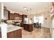 Open kitchen with dark wood cabinets, stainless steel appliances, and a dining area with natural light at 120 Tranquil Ct, Locust, NC 28097