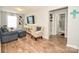 Cozy living room featuring hardwood floors, a comfortable sofa, stylish armchair and a mounted television at 120 Tranquil Ct, Locust, NC 28097