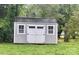 New outbuilding with grey siding, white trim and black hardware adds storage to the property at 132 Swimmers Ln, Salisbury, NC 28146