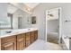 Bathroom with double vanity, large mirror, and glass block window offering plenty of light at 1458 Bedlington Nw Dr, Charlotte, NC 28269