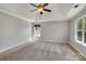 A spacious bedroom with neutral walls, plush carpeting, a ceiling fan, and two windows providing natural light at 1458 Bedlington Nw Dr, Charlotte, NC 28269