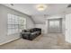 Bonus room includes carpet floor, natural light, and gray sofa at 1458 Bedlington Nw Dr, Charlotte, NC 28269