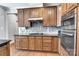 Kitchen with dark wood cabinetry, granite countertops, and mosaic tile backsplash at 1458 Bedlington Nw Dr, Charlotte, NC 28269