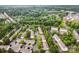 An aerial view of neighborhood with tree lined streets and city scape in the distance at 15554 Stronvar House Ln, Charlotte, NC 28277